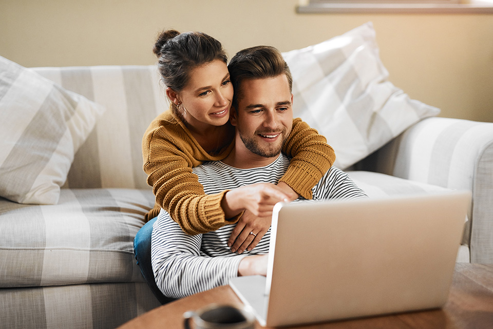 Eine Frau und ein Mann, die etwas auf einem Laptop nachschauen